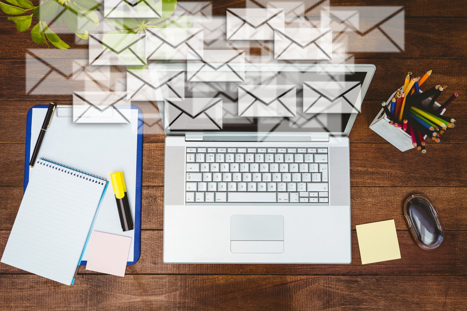 Mesa de trabalho com notebook e envelopes, representando e-mail marketing